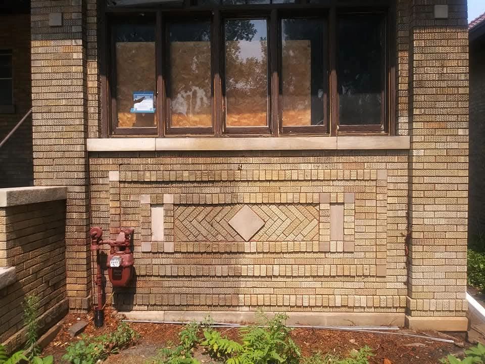 Cleaned ornamental tan-brick facade with a decorative diamond pattern below the windows